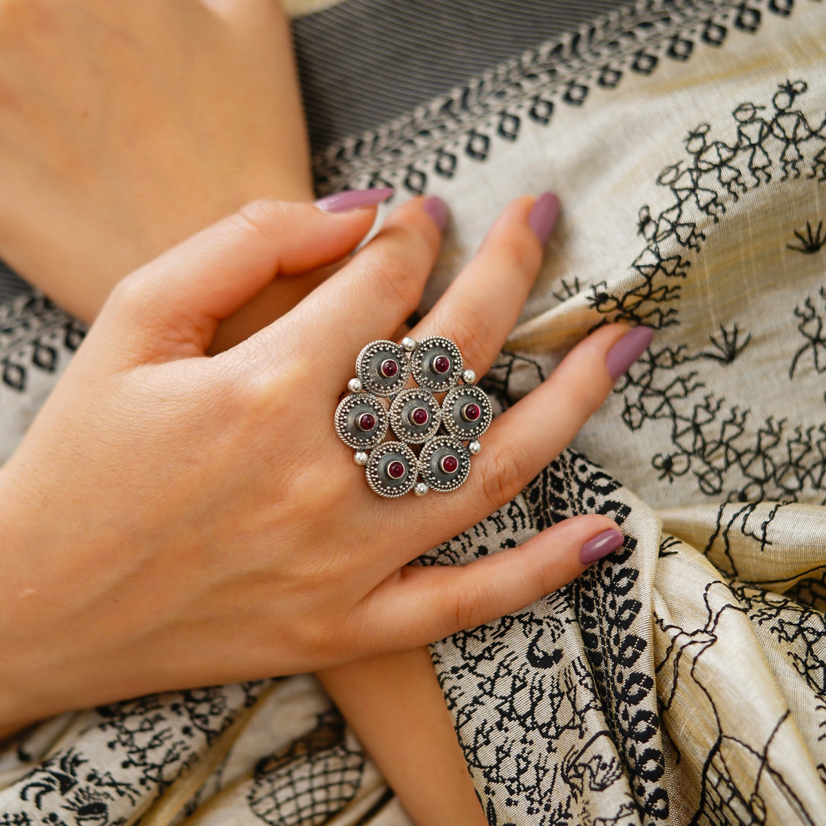 Side view Hand wearing a women’s statement ring, handcrafted in Jaipur from 925 sterling silver with Red Stone, hexagon rawa detailing and an intricate central star motif. This Red Stone adjustable Ring features an oxidized silver finish and bold ethnic jewellery style, ideal for occasion wear. Jaipur handmade jewellery makes a beautiful gift for her, birthday gift for her or anniversary gift.