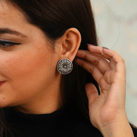 Woman wearing an oxidized 925 silver stud earring with a black topwear.