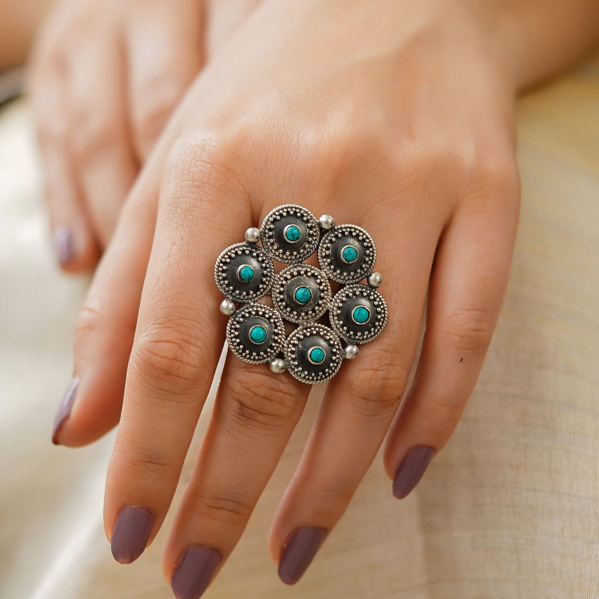 Hand wearing a women’s statement ring, handcrafted in Jaipur from 925 sterling silver with Turquoise, hexagon rawa detailing and an intricate central star motif. This Turquoise Stone adjustable Ring features an oxidized silver finish and bold ethnic jewellery style, ideal for occasion wear. Jaipur handmade jewellery makes a beautiful gift for her, birthday gift for her or anniversary gift.