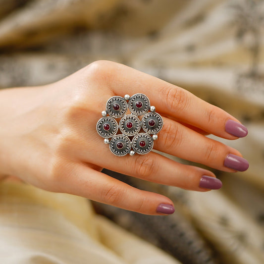 Close up wearing a women’s statement ring, handcrafted in Jaipur from 925 sterling silver with Red Stone, hexagon rawa detailing and an intricate central star motif. This Red Stone adjustable Ring features an oxidized silver finish and bold ethnic jewellery style, ideal for occasion wear. Jaipur handmade jewellery makes a beautiful gift for her, birthday gift for her or anniversary gift.